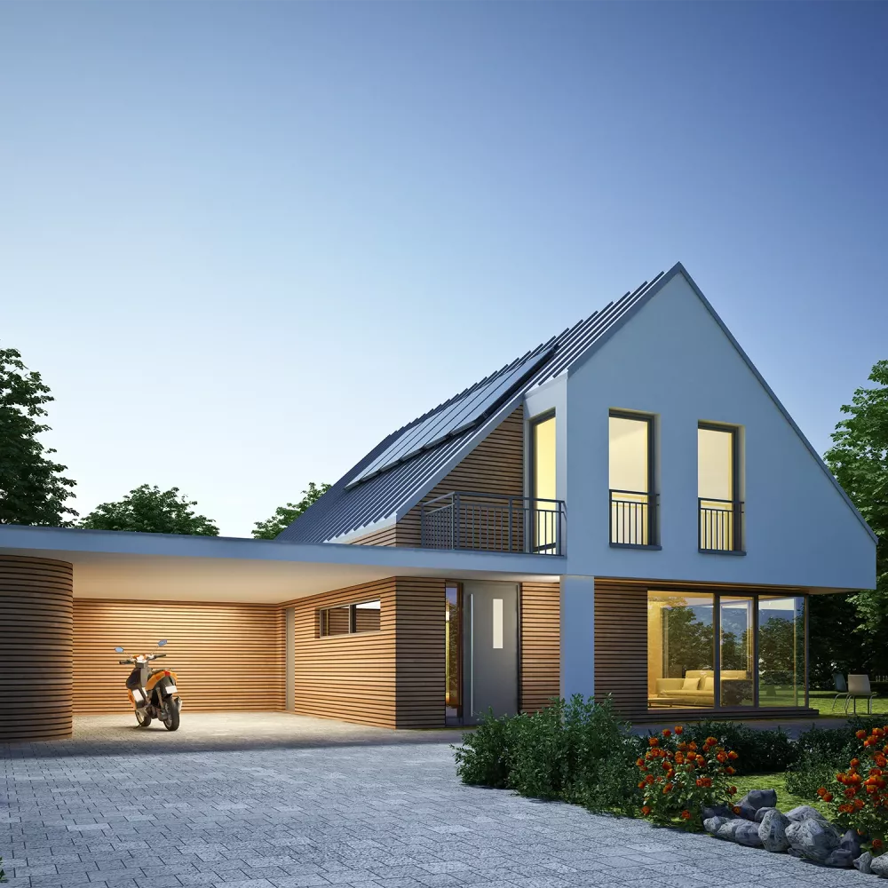 Modern detached house at dusk with solar panels on a pitched roof, illuminated windows, wooden facade elements, and a covered carport.