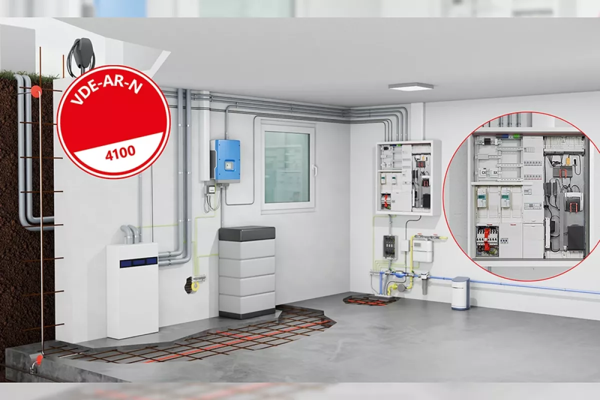 Sala técnica que contiene equipos eléctricos, tuberías y un dispositivo azul fijado a la pared. Un círculo rojo resalta un panel de control abierto. Una etiqueta roja indica «VDE-AR-N 4100».